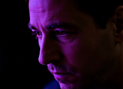 Potret close-up wajah trader dengan pencahayaan ungu setengah bayangan, menampilkan kelelahan sekaligus tekad bangkit.